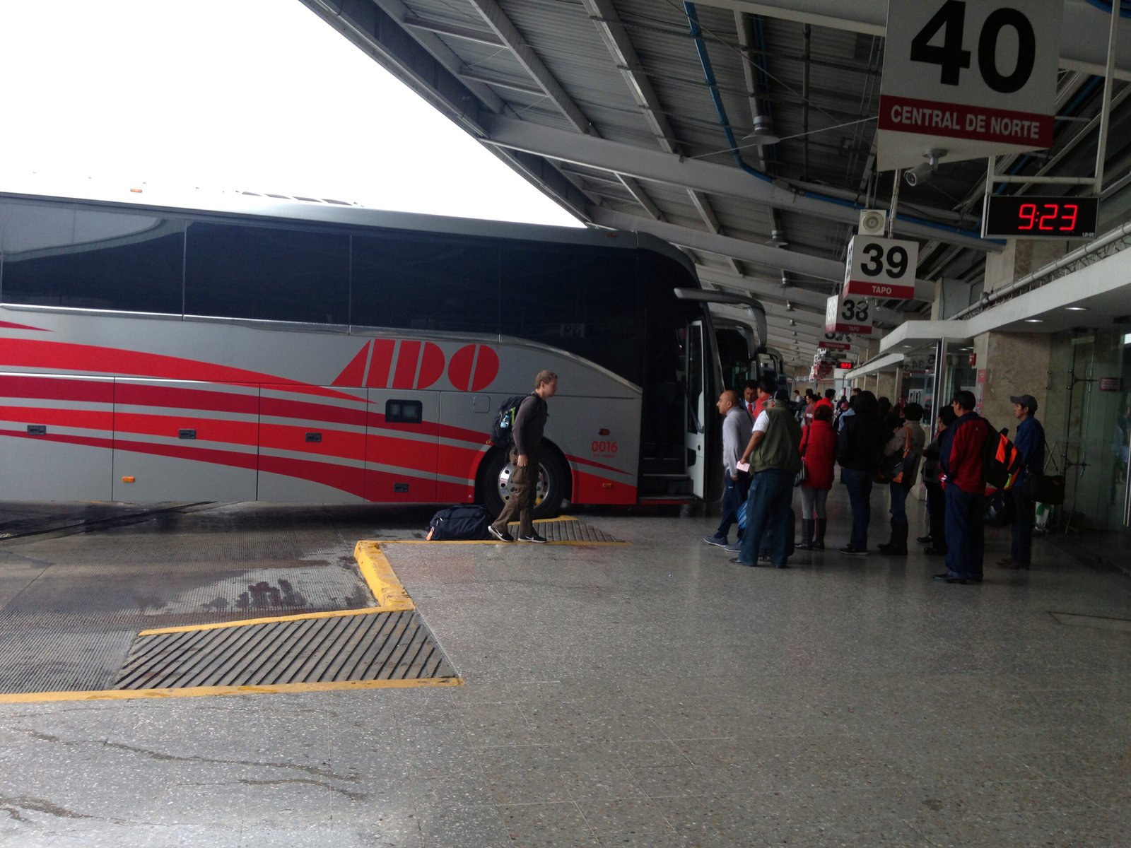 Passengers boarding at ADO lanes in a Mexican bus terminal