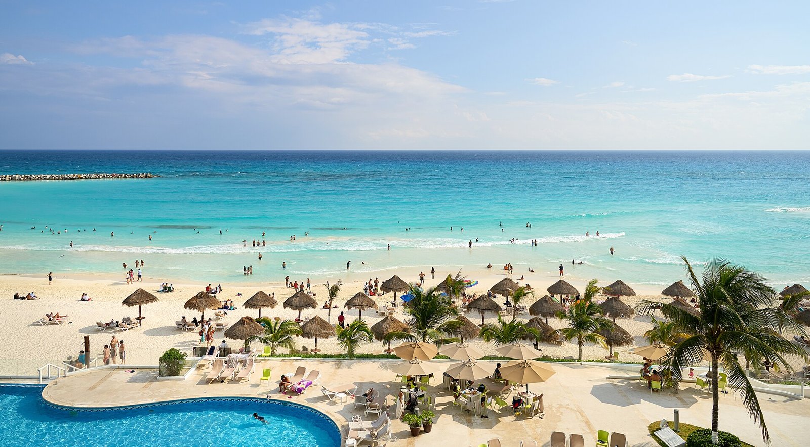 Turquoise water and swimmers seen from a hotel balcony in Cancun
