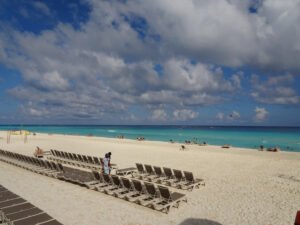 Rows of beach loungers with a kiteboarder in the water off the Cancún Hotel Zone, Quintana Roo, Mexico