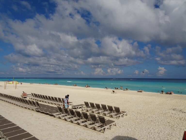 Rows of beach loungers with a kiteboarder in the water off the Cancún Hotel Zone, Quintana Roo, Mexico