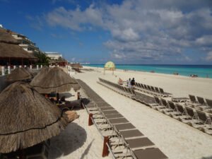 Palapas and rows of beach loungers on a beach in the Cancún Hotel Zone, Quintana Roo, Mexico