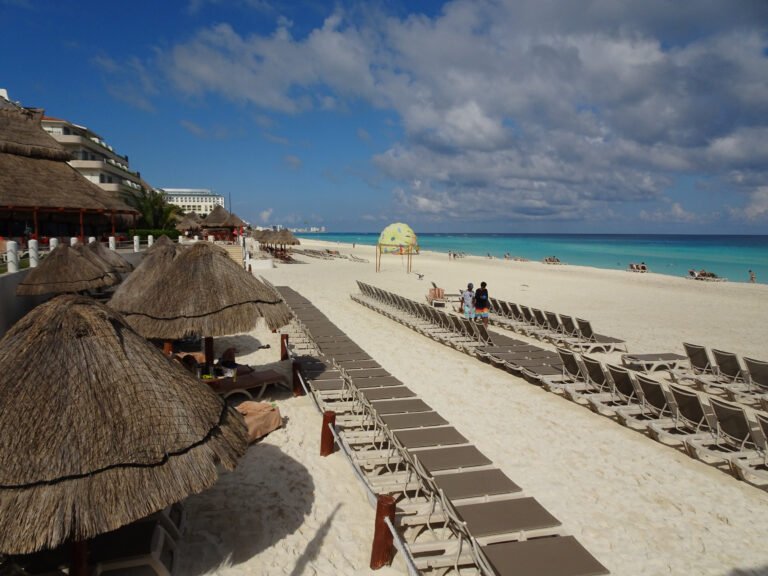 Palapas and rows of beach loungers on a beach in the Cancún Hotel Zone, Quintana Roo, Mexico