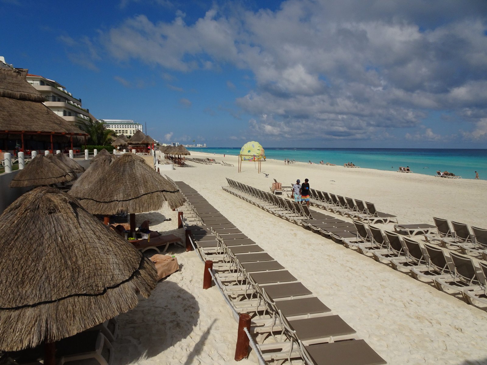 Palapas and rows of beach loungers on a beach in the Cancún Hotel Zone, Quintana Roo, Mexico