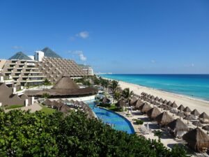 Resort pool and palapas overlooking the beach in Cancun's Hotel Zone