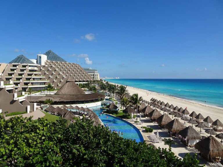 Resort pool and palapas overlooking the beach in Cancun's Hotel Zone