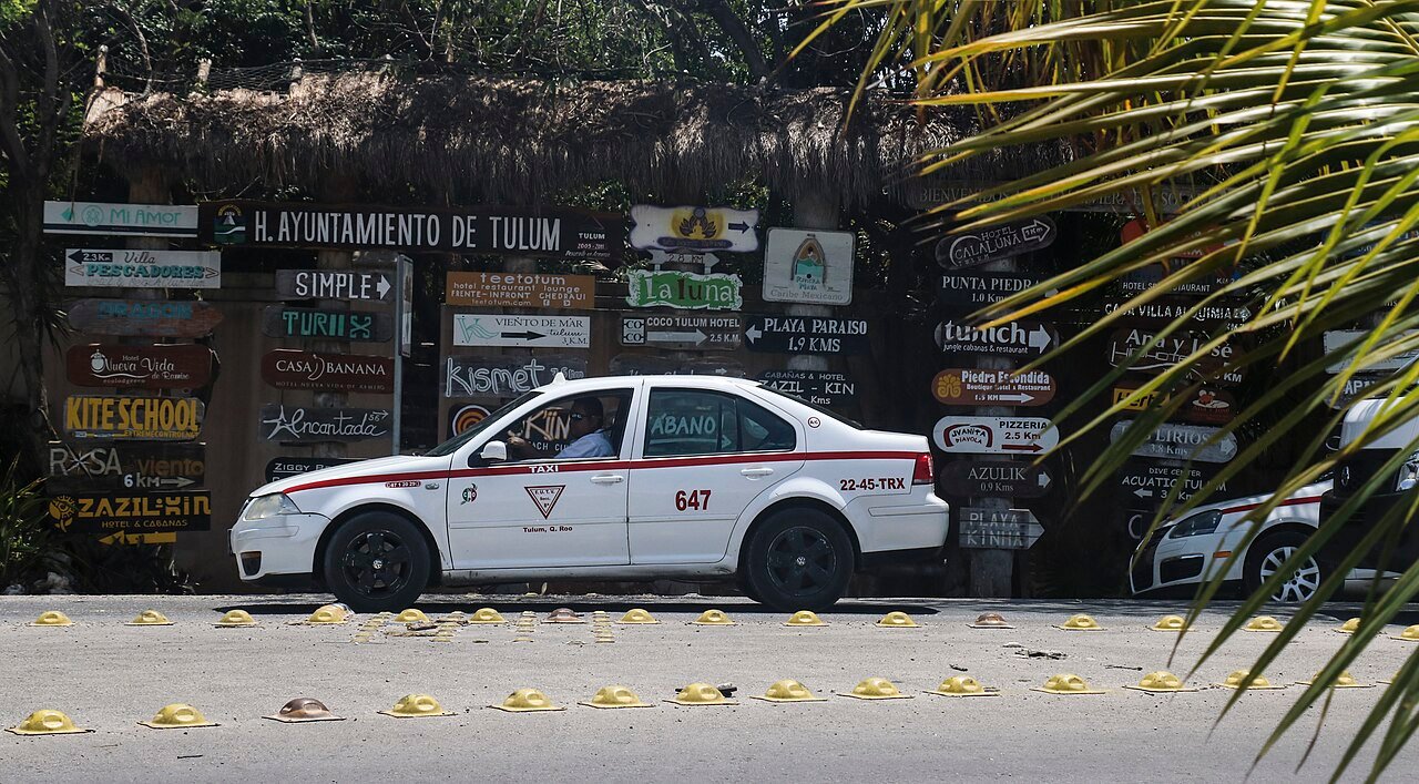 Taxi blanco estacionado en una calle de Tulum, Quintana Roo