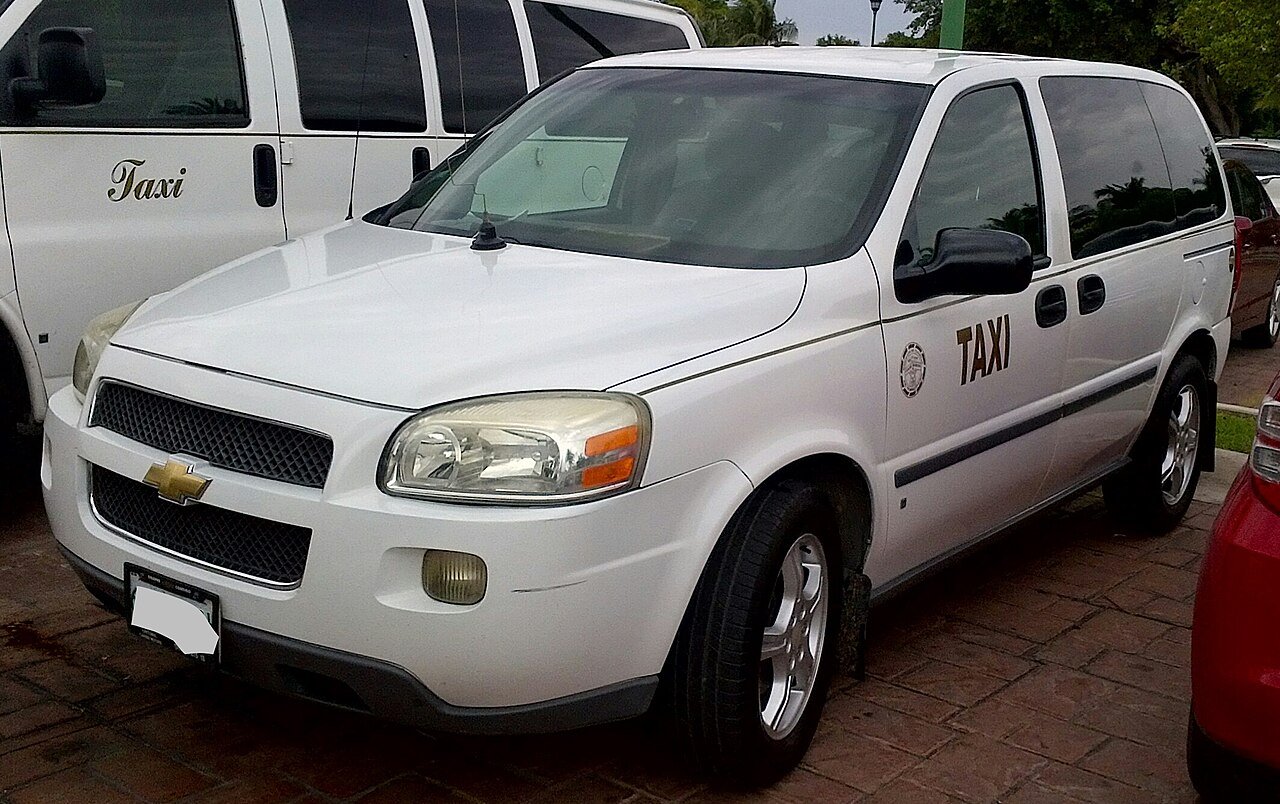 Van blanca de taxi autorizado de hotel en la zona de Cancún