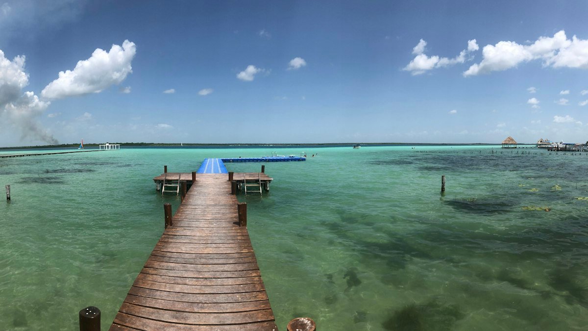 Wooden pier stretching over clear shallow water at Bacalar Lagoon, Quintana Roo