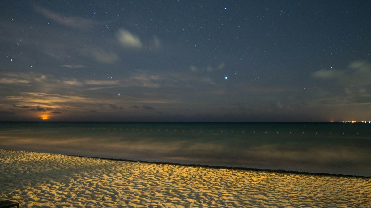 Dark beach and sea under a night sky in Cancún, Quintana Roo