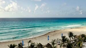 Wide view of blue Caribbean water and palm trees on a beach near Punta Nizuc, Cancún Hotel Zone