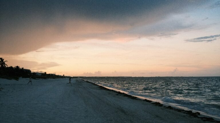 Beach in Cancún at sunset with dramatic clouds over the Caribbean
