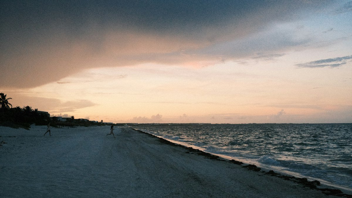 Beach in Cancún at sunset with dramatic clouds over the Caribbean