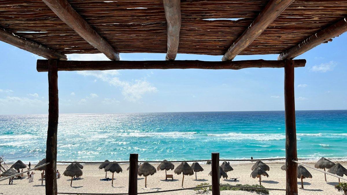 Beach umbrellas facing the turquoise Caribbean on a Cancún beach