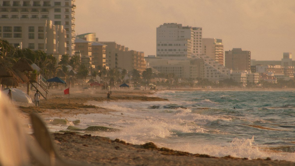 Visitors walking and relaxing on a sunny beach in Cancún