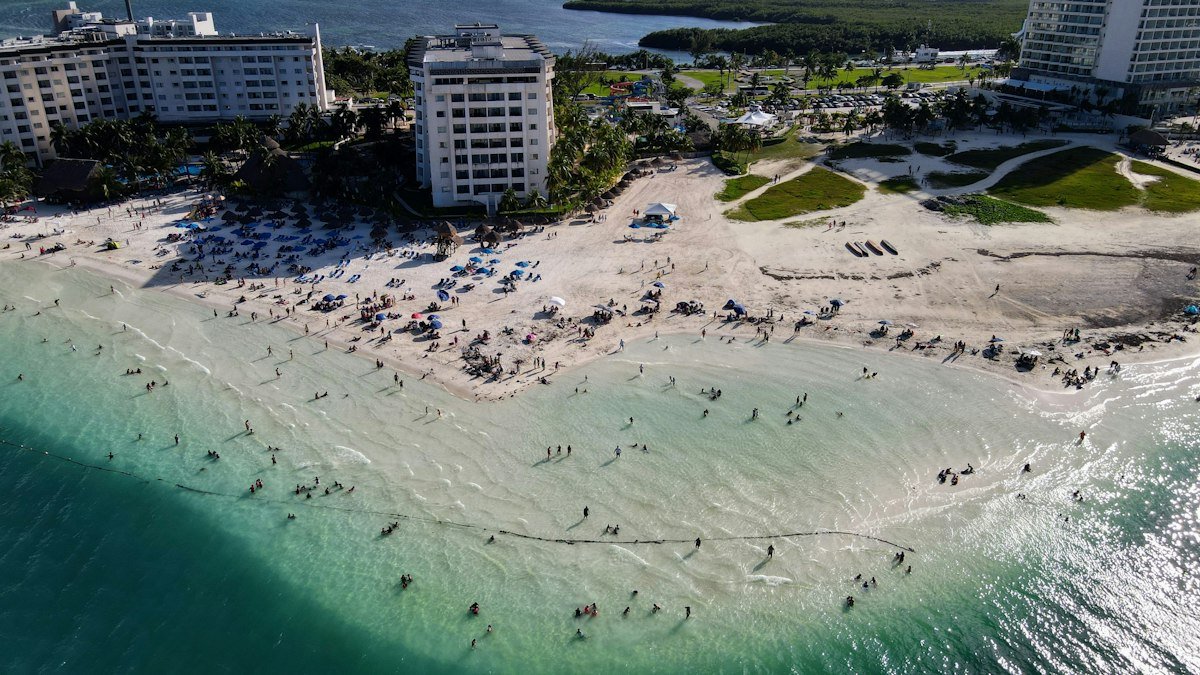 Aerial view of swimmers and sunbathers on a busy Cancún beach