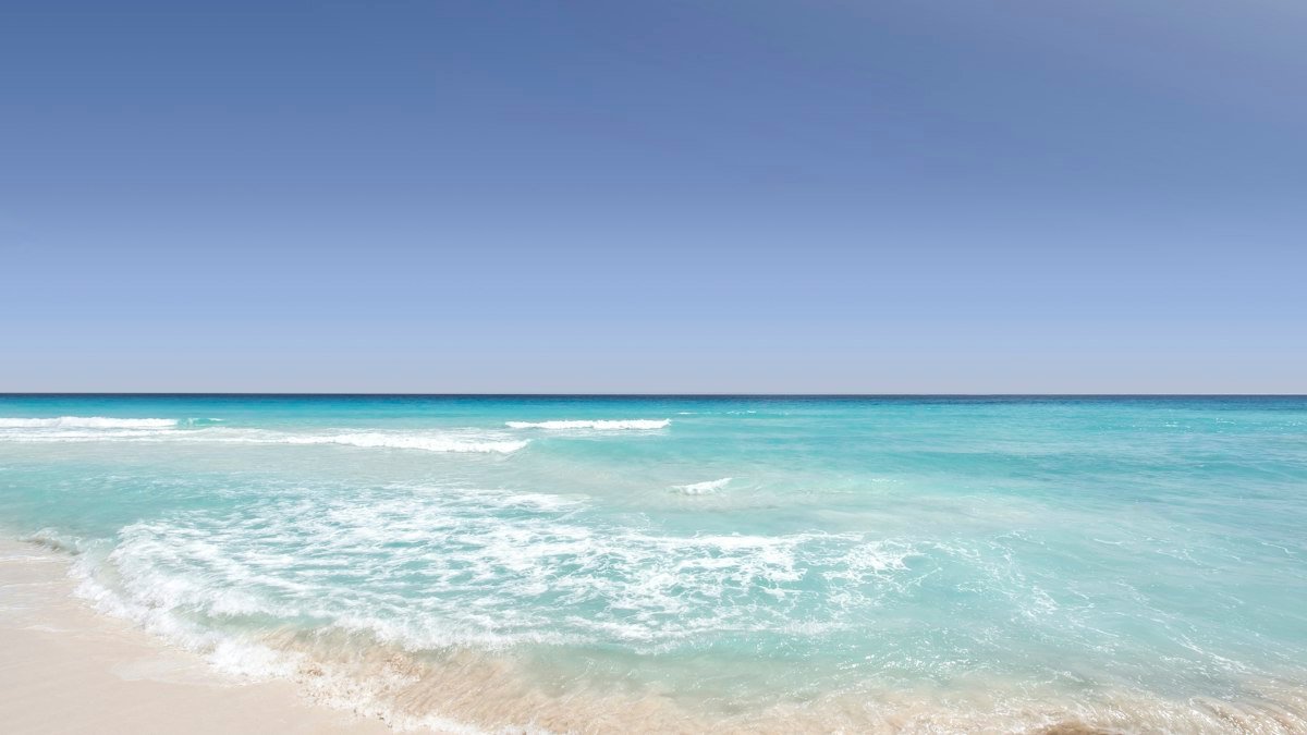 Clear turquoise water lapping the shore in Cancún