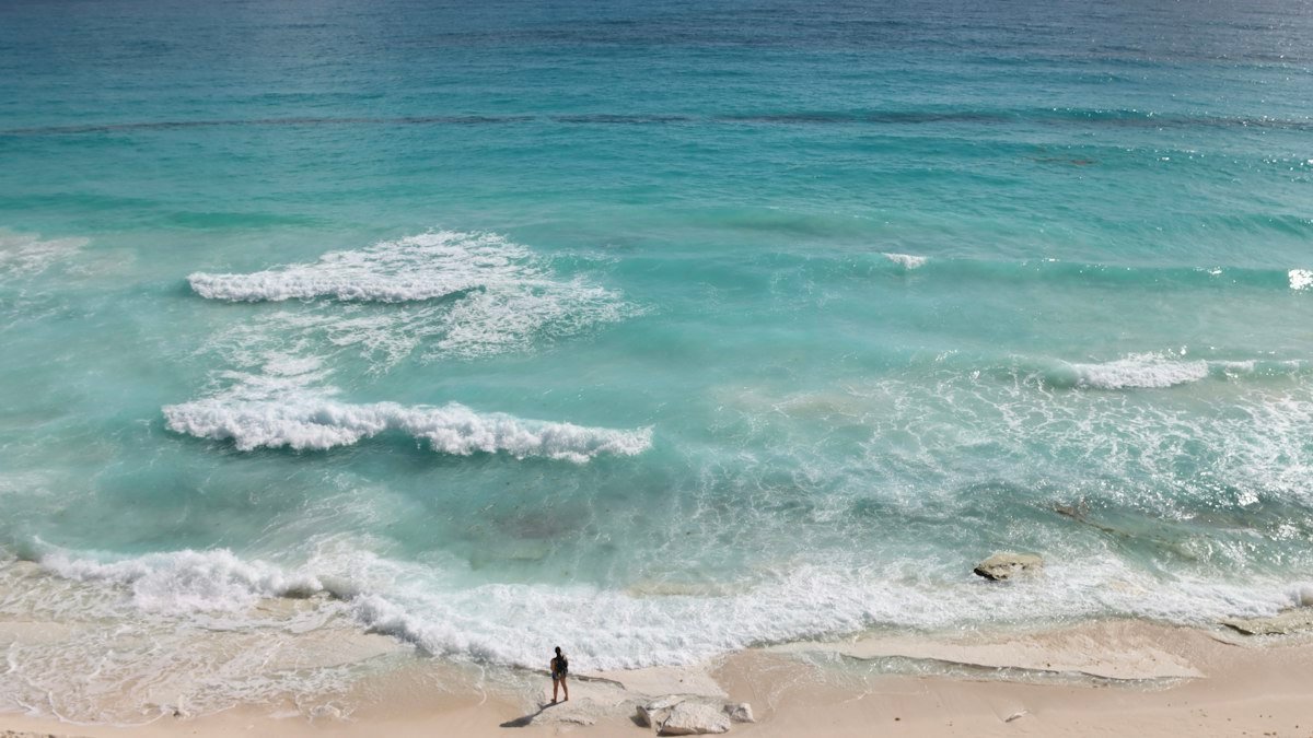 Person standing on the sand by the Caribbean in Cancún