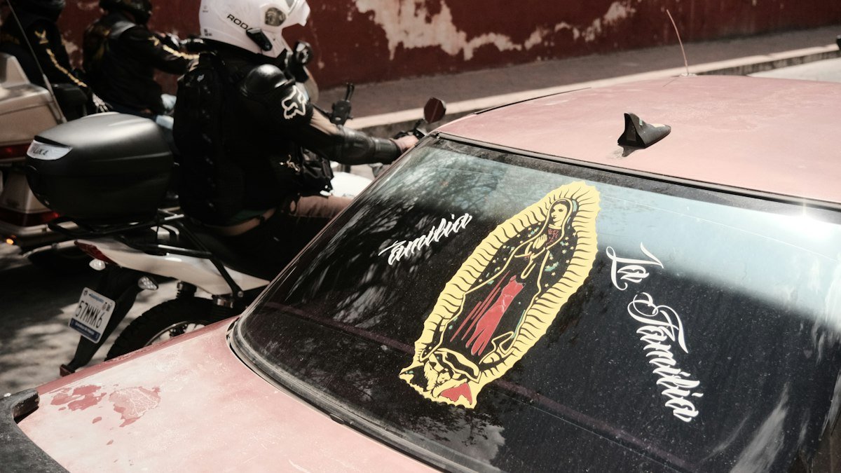 Police officer on a motorcycle next to a car on a street in Cancún