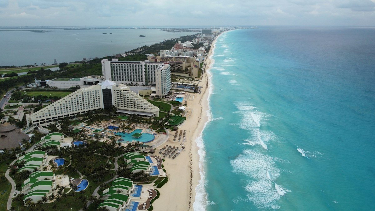 Aerial view of a resort, beach and surf in Cancun