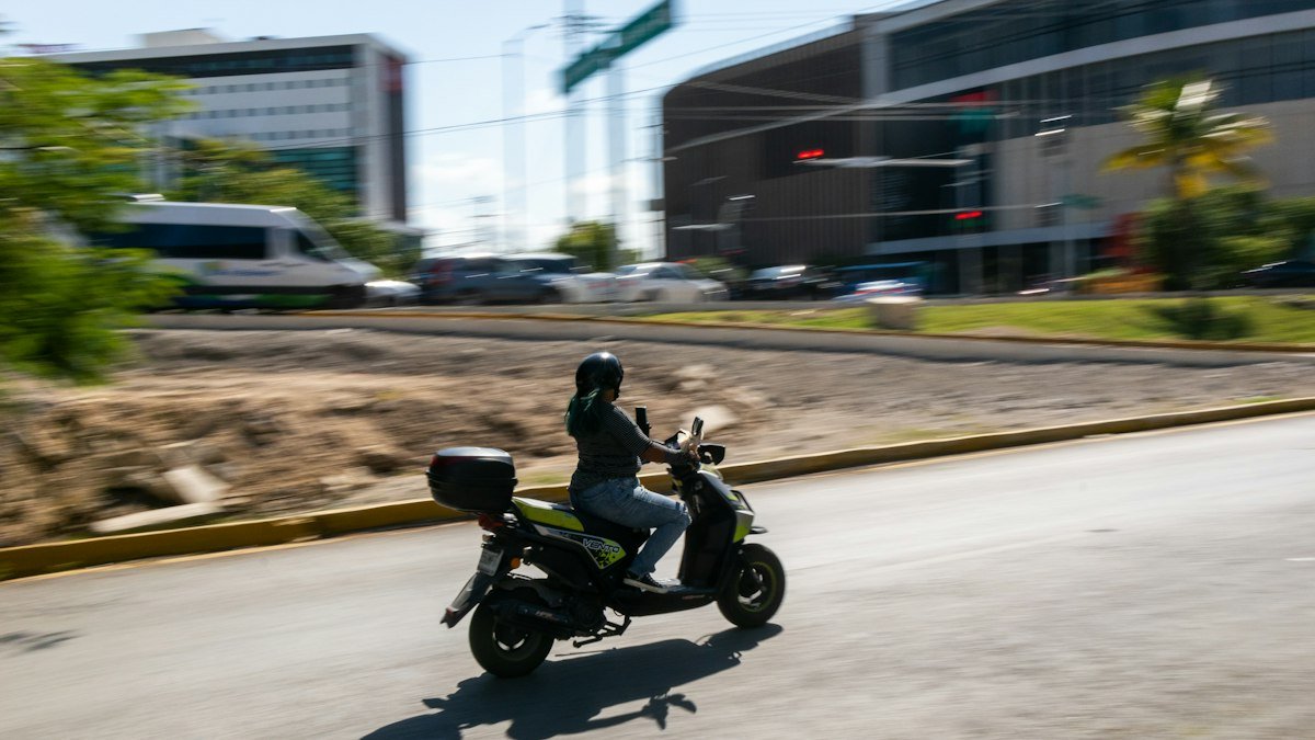 Motor scooter riding down a street in Cancún, Quintana Roo