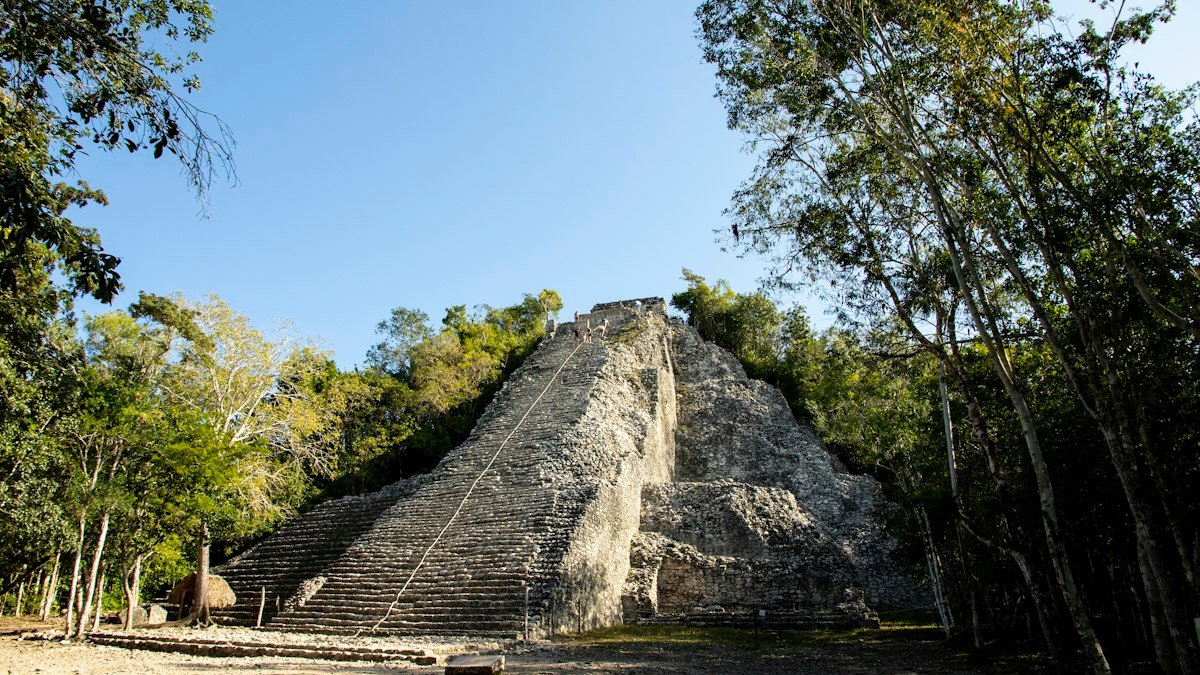 Stepped Maya temple beside a forest path at the Cobá ruins, Quintana Roo