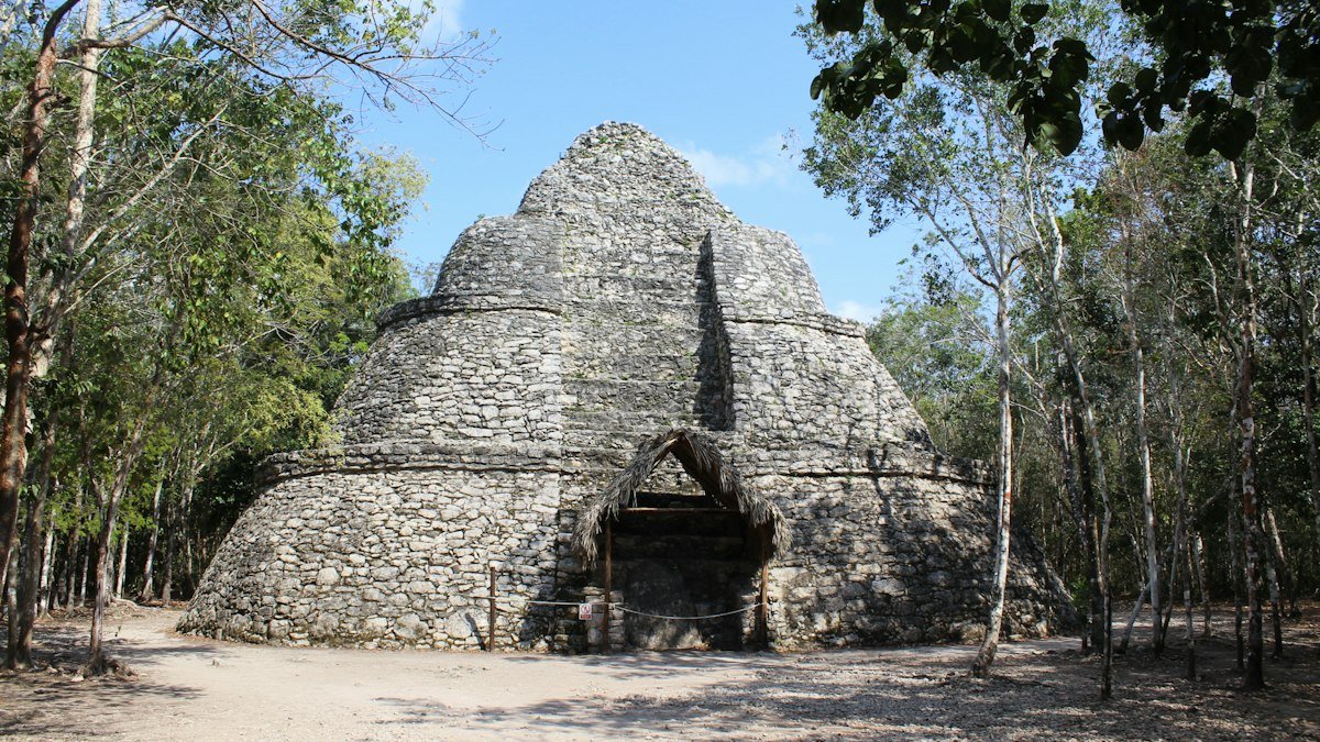 Stone building at the Cobá ruins with a pyramid visible behind it, Quintana Roo