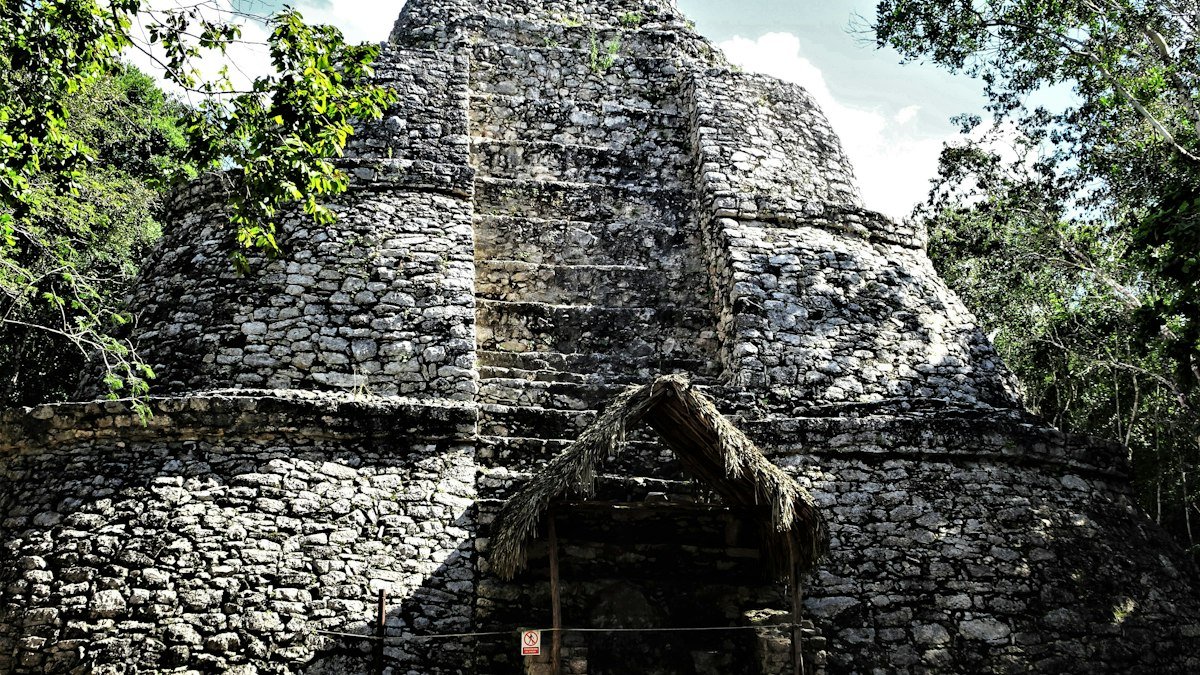 Ancient stone temple with a doorway among trees at Cobá, Quintana Roo