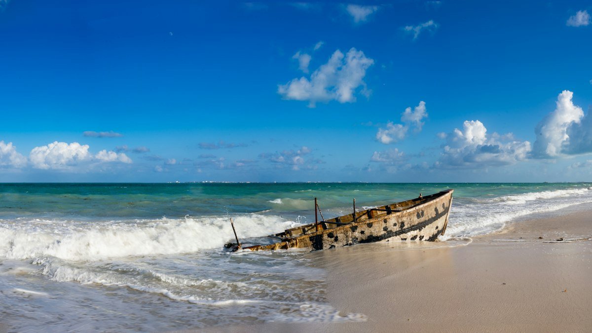 Small boat pulled up on the sandy shore in Costa Mujeres, on the road north to Isla Blanca