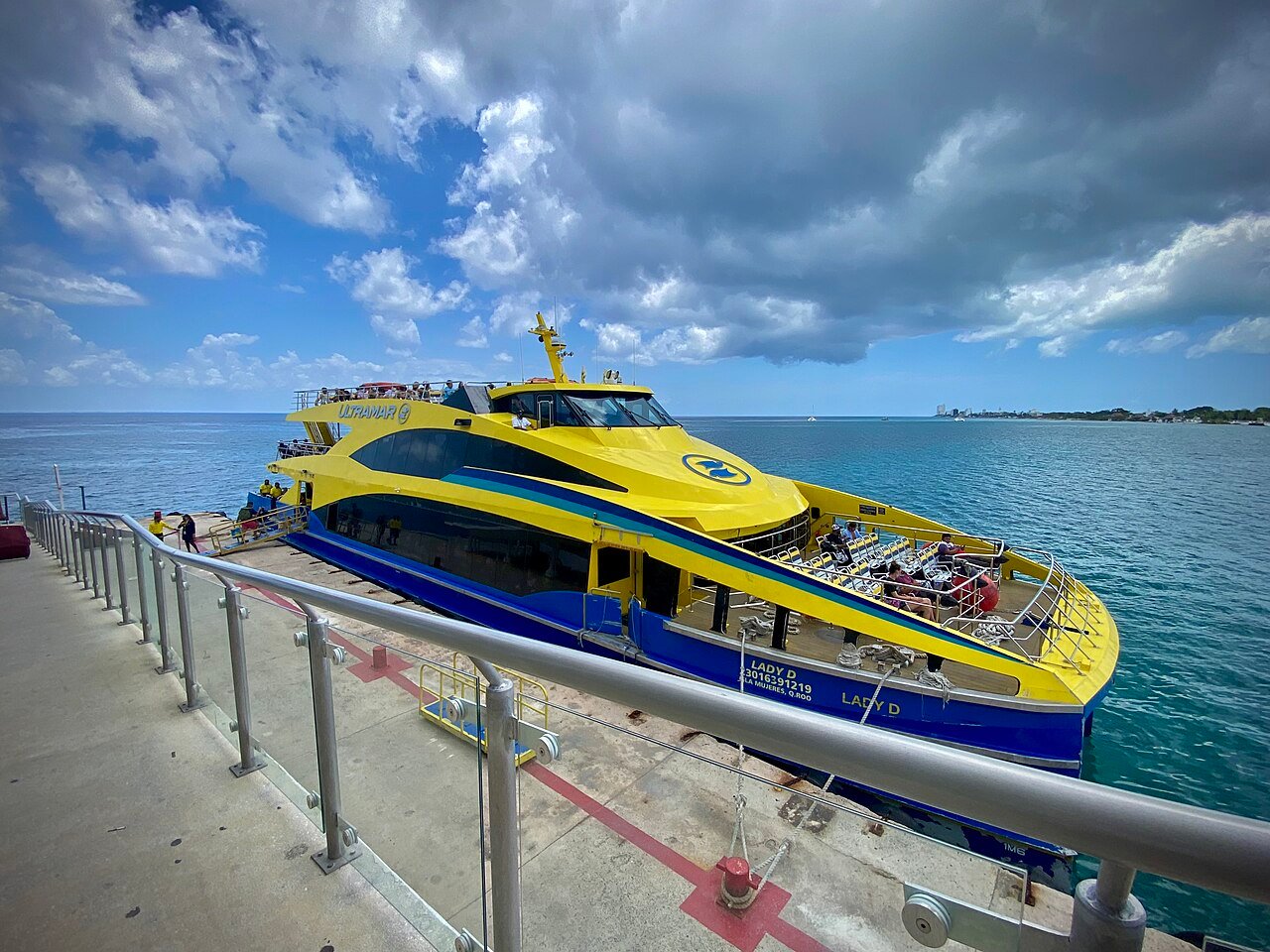 Yellow and blue passenger ferry to the mainland at the dock in San Miguel de Cozumel