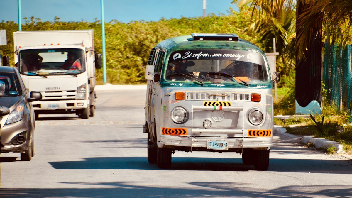 Red and white vintage Volkswagen van parked on a sandy street in Mahahual