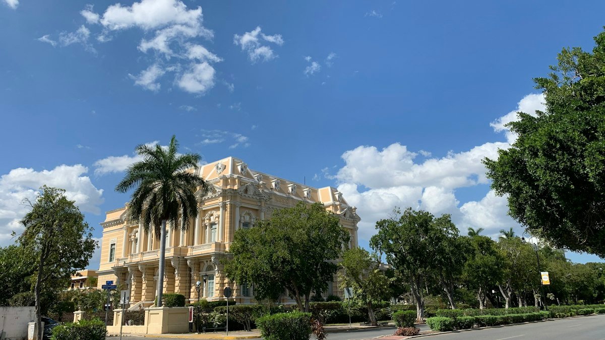 Palacio Cantón with palm trees under a blue sky on Paseo de Montejo, Mérida, Yucatán