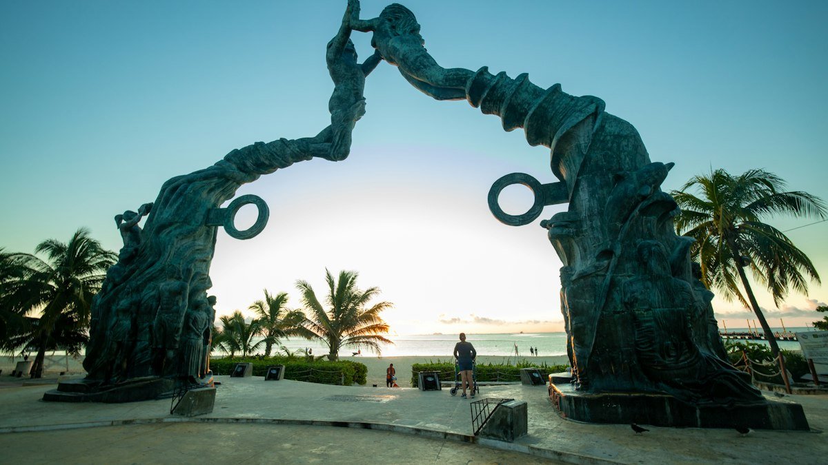 Portal Maya bronze arch sculpture on the beach at Fundadores Park in Playa del Carmen, next to the Cozumel ferry pier