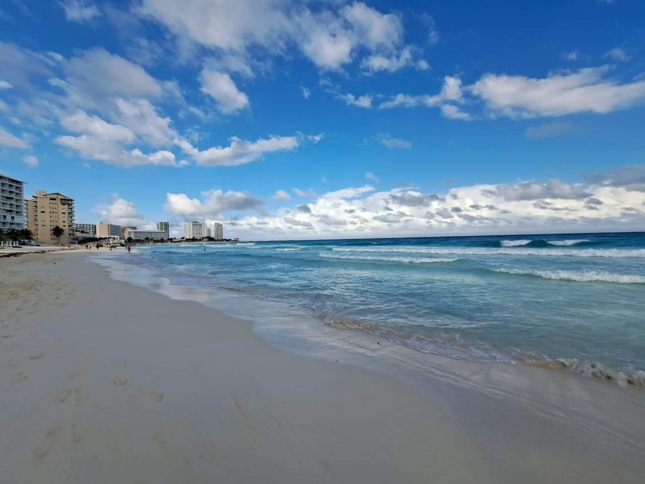 Empty beach under scattered clouds on a morning at Playa Tortugas in Cancun