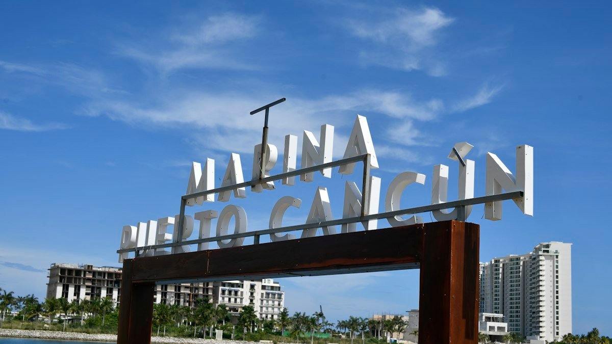 Puerto Cancún marina sign with turquoise water and towers in Cancún